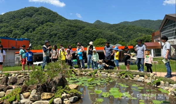 전남자연탐구원이 운영한 가족과 함께하는 환경의 날 참가자들이 탐구원 내 연못에서 들꽃 전문가 설명을 듣고 있다(사진=전남자연탐구원 제공)